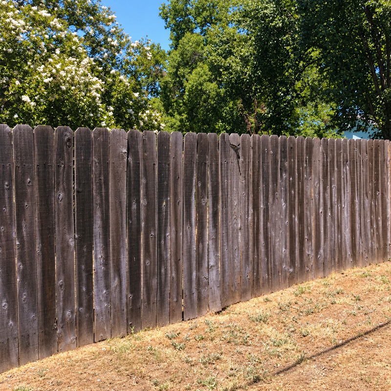 Before: gray, weathered wood fence